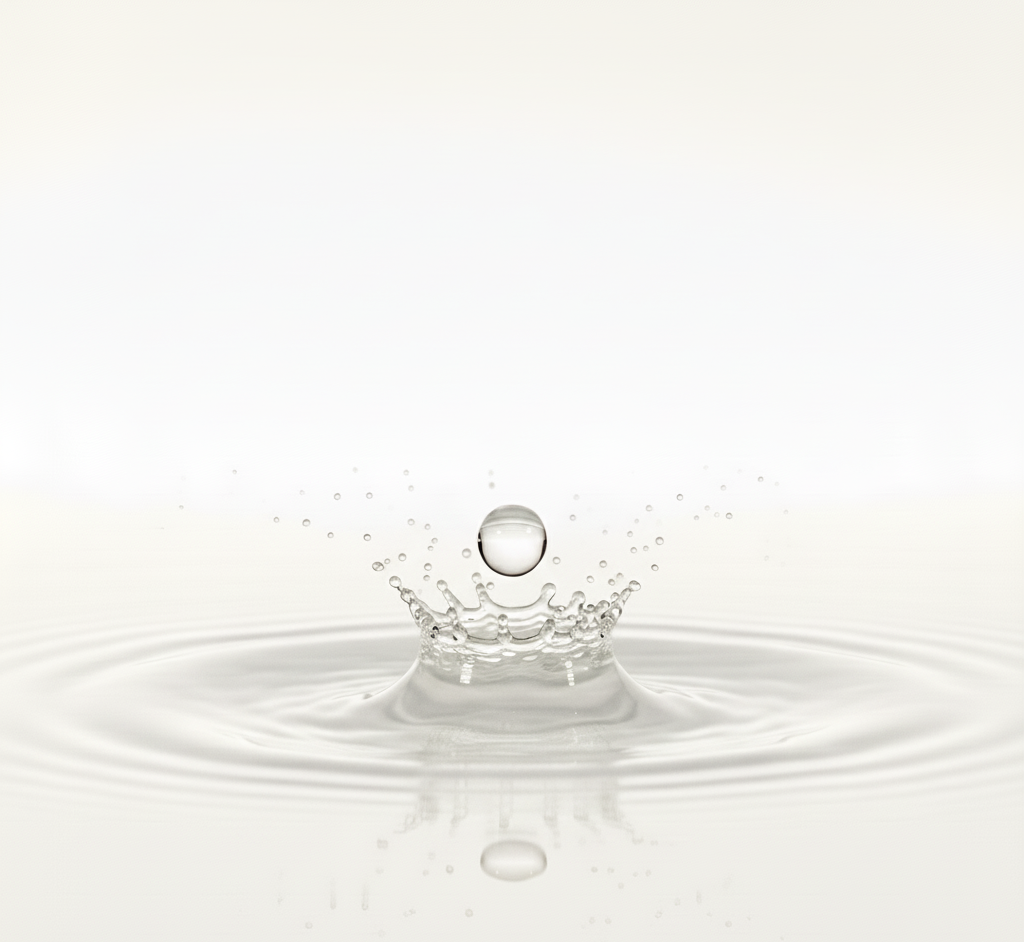 Water droplet creating ripples on a white background